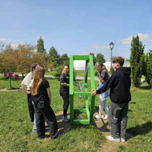 Nauka przez zabawę – uczniowie testują zieloną huśtawkę Newtona, poznając zasady dynamiki i przekazywania energii w praktyce.