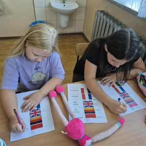 Uczniowie podczas pracy z kartami – nauka powitań w różnych językach.  Ćwiczenia językowe – poznawanie słów grzecznościowych i ich zapisywanie.