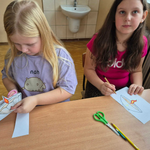 Dziewczynki z klasy III starannie kolorują i wycinają własne światełka pamięci.