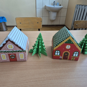 Papierowe choinki i domki – efekt końcowy zajęć plastycznych inspirowanych świąteczną tematyką.