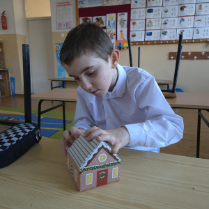 Składanie papierowego domku – ćwiczenie koncentracji, precyzji i cierpliwości podczas zajęć plastycznych.