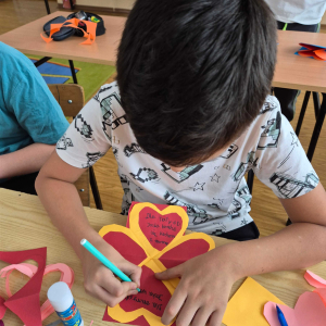 Uczeń klasy III na walentynkowych warsztatach z pedagogiem specjalnym.