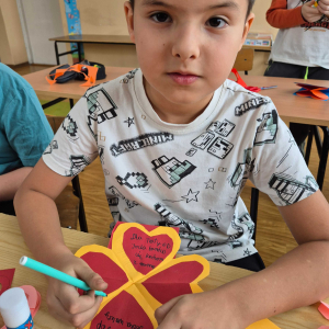 Uczeń klasy III na walentynkowych warsztatach z pedagogiem specjalnym.